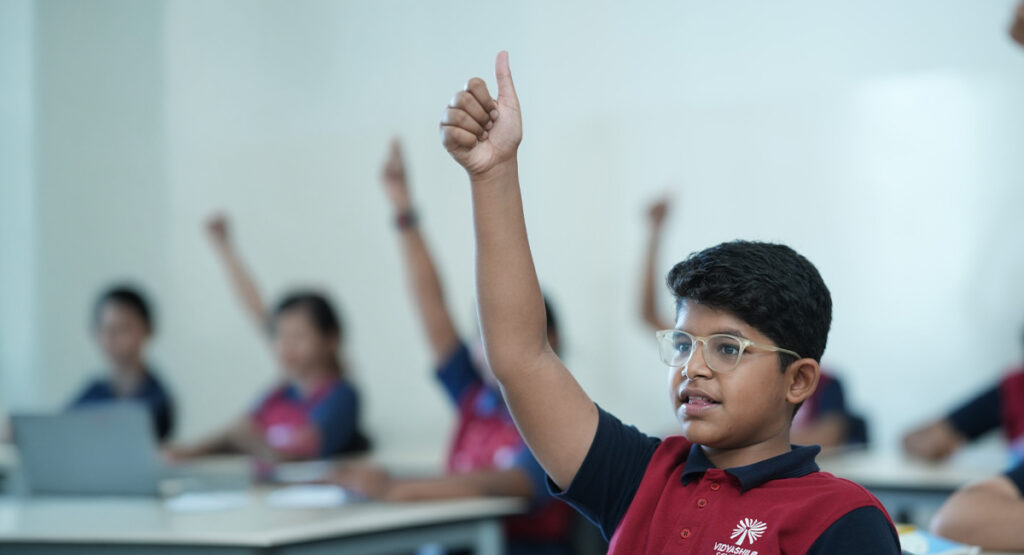 Student raising hand during classroom learning